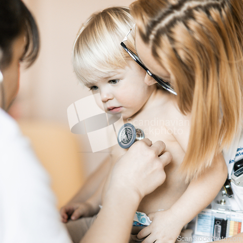 Image of Doctor holding stethoscope and listening to child's heartbeat. Regular checkout at pediatrician at clinic or hospital. Healthcare and medical concept.