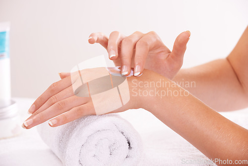 Image of Touch skin, cream and hands in spa, closeup and massage on towel for care. Fingers, nails or person apply lotion in treatment, natural cosmetics or dermatology moisturizer, beauty health and manicure