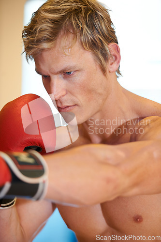 Image of Man, fitness and boxing with punching in gym for vision, power or exercise for fight, wellness or health. Contact sports training, athlete and person in gloves, action or martial arts workout in club