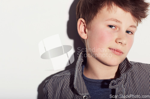 Image of Teenager, portrait and boy with fashion in studio, white background with a smirk or smile. Cool, style and child with confidence in trendy clothes, outfit and pride in personality on backdrop