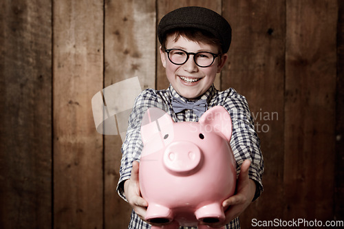 Image of Child, piggy bank or excited in portrait by studio background, savings or finance lesson in youth. Boy, smile and face in coin banking of small change and cash learning in vintage fashion in mockup