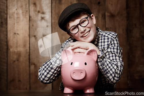 Image of Piggy bank, portrait and boy child smile with savings, growth or investment success in his home. Finance, learning and face of excited kid with money box for future education, funding or security