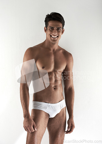 Image of Portrait, muscle and man with underwear, smile and confident guy isolated on a white studio background. Person, mockup space and model with body, healthy and wellness with fitness, beauty and natural