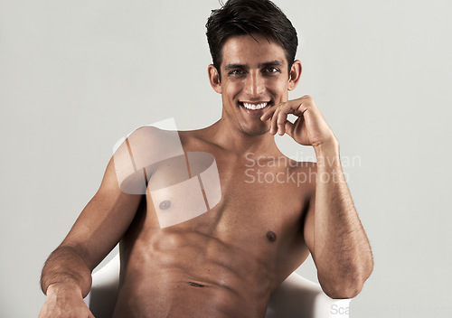 Image of Muscular, man and shirtless portrait in chair to relax in white background of studio. Happy, model and person with a smile for wellness, confidence and bodybuilder with a six pack from fitness