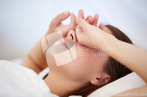 Image of Tired, wake up and woman cover eyes in bed, sleeping or fatigue in morning from insomnia. Frustrated, person and hands on face, exhausted from stress in dream or nightmare in bedroom at home