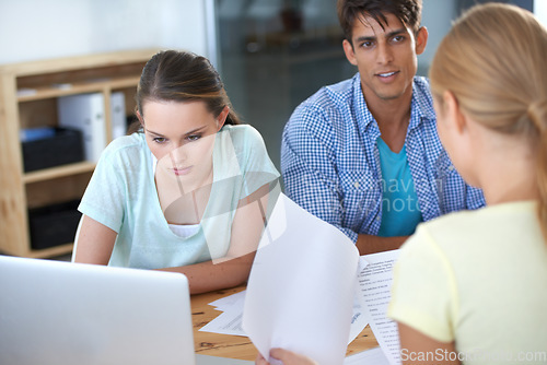 Image of Business people, documents and laptop for meeting, office planning and teamwork, collaboration or research. Young group of men, women or employees with paperwork, financial strategy and computer