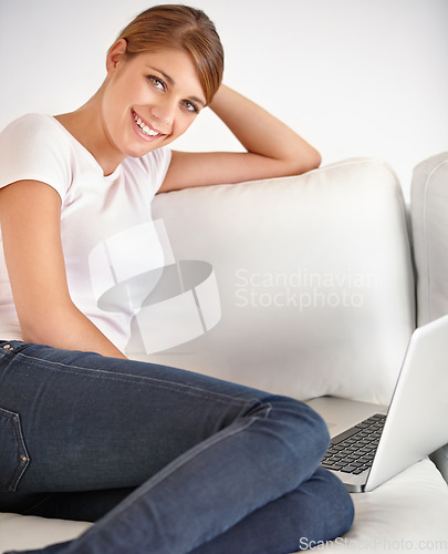 Image of Woman, portrait and smile with laptop on sofa to watch movies, digital subscription and streaming multimedia at home. Computer, online shopping and relax to update blog, social network and internet