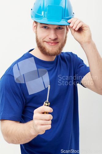 Image of Construction worker man, screwdriver and studio portrait with smile, helmet and ready by white background. Person, handyman or contract with tools, safety and pride for job, services and maintenance