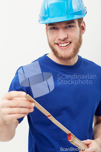 Image of Portrait, builder and man with a hard hat, measurement tape and smile isolated on a white studio background. Face, person and construction worker with a helmet, safety and equipment with entrepreneur