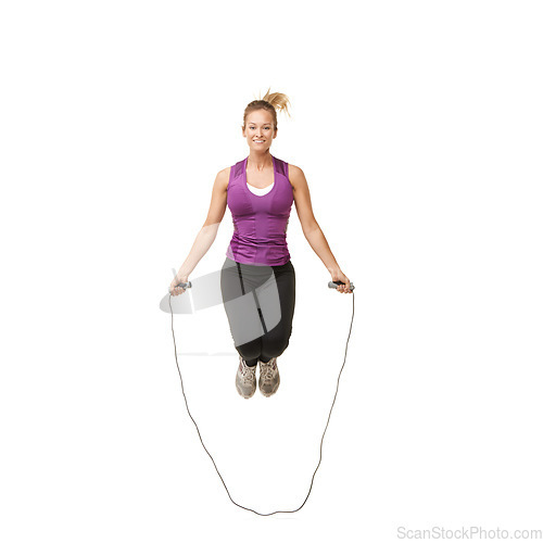 Image of Jump, skipping rope and portrait of woman on a white background for fitness, workout and training. Sports, happy and isolated person with gym equipment for health, wellness and exercise in studio