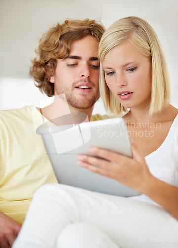 Image of Research, tablet and young couple on sofa browse on social media or internet at apartment. Happy, digital technology and man and woman from Australia relax and scroll on website in lounge at home.