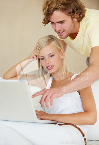 Image of Laptop, choice and couple on sofa with social media search, movies or streaming at home together. Online shopping, relax and people in living room checking ecommerce, website or deal, sale or survey