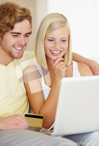 Image of Couple, credit card and thinking on computer for online shopping, loan choice or digital money on sofa at home. Happy woman and man on laptop for internet banking, website payment or e commerce ideas