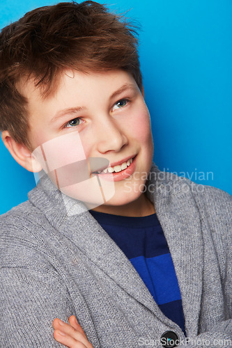 Image of Fashion, thinking and boy child in studio with arms crossed confidence, smile or positive attitude on blue background. Style, face and proud fashionable kid model with cool, outfit or clothing choice