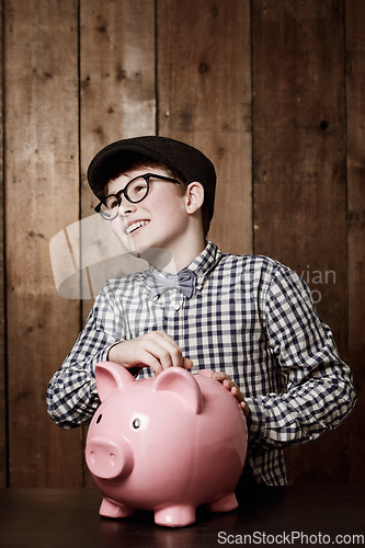 Image of Piggy bank, money and boy child with savings, growth or investment, planning or learning at home. Happy, budget and kid in a house with coin, container or cash box for future, financial and security