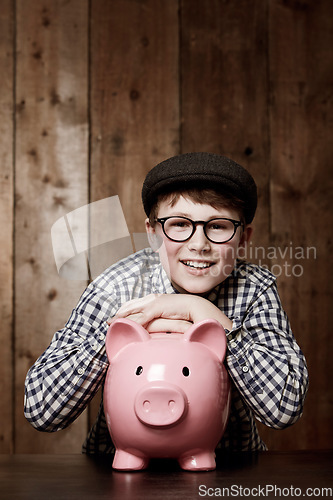 Image of Piggy bank, smile and portrait of boy child with savings, growth or investment success in his home. Finance, learning and face of excited kid with money box for future education, funding or security