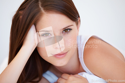 Image of Smile, beauty and portrait of woman on bed for relaxing with positive, good and confident attitude. Happy, calm and young female person from Canada laying and resting in bedroom of modern apartment.