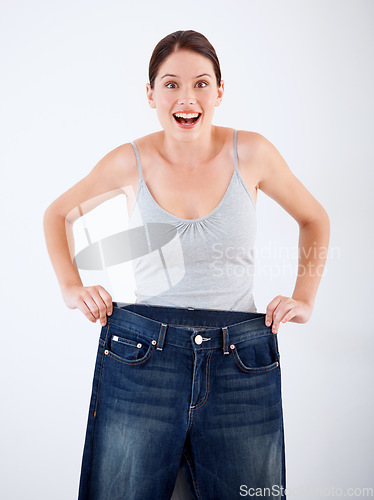 Image of Woman, lose weight and portrait of surprise with jeans, change in size or white background in studio. Wow, shocked and person with crazy transformation in fitness, health or comparison in denim pants