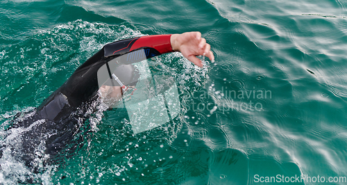 Image of A professional triathlete trains with unwavering dedication for an upcoming competition at a lake, emanating a sense of athleticism and profound commitment to excellence.