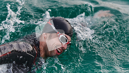 Image of A professional triathlete trains with unwavering dedication for an upcoming competition at a lake, emanating a sense of athleticism and profound commitment to excellence.