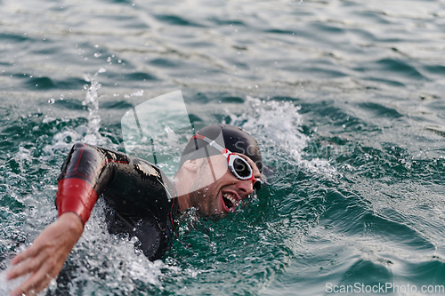 Image of A professional triathlete trains with unwavering dedication for an upcoming competition at a lake, emanating a sense of athleticism and profound commitment to excellence.