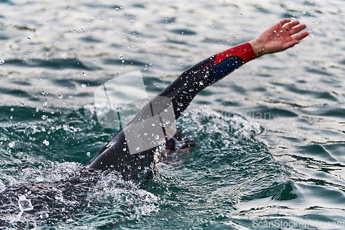 Image of A professional triathlete trains with unwavering dedication for an upcoming competition at a lake, emanating a sense of athleticism and profound commitment to excellence.