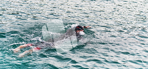 Image of A professional triathlete trains with unwavering dedication for an upcoming competition at a lake, emanating a sense of athleticism and profound commitment to excellence.