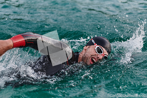 Image of A professional triathlete trains with unwavering dedication for an upcoming competition at a lake, emanating a sense of athleticism and profound commitment to excellence.