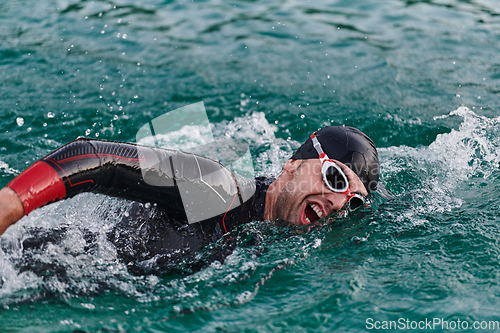 Image of A professional triathlete trains with unwavering dedication for an upcoming competition at a lake, emanating a sense of athleticism and profound commitment to excellence.