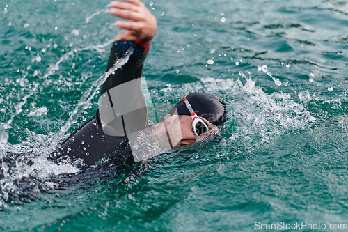 Image of A professional triathlete trains with unwavering dedication for an upcoming competition at a lake, emanating a sense of athleticism and profound commitment to excellence.