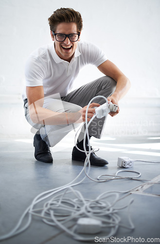 Image of Portrait, electrician or man on cable connection, power and electricity in office. IT, technician and person plug wire, funny engineer and technology professional, geek and excited nerd in glasses