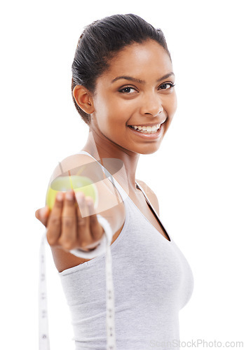 Image of Happy woman, portrait and lose weight with a measuring tape and apple in white background or studio. Indian, model and healthy food for results in fitness, wellness and diet with nutrition and fruit
