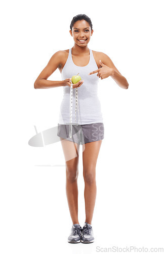 Image of Woman, lose weight and pointing to measuring tape and apple in white background or studio. Indian, model and happy with results of fitness, wellness and diet with healthy food, nutrition and fruit