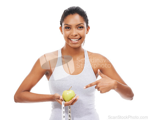 Image of Woman, pointing and lose weight with a measuring tape and apple in white background or studio. Happy, model and healthy food for results in fitness, wellness and diet with nutrition and fruit