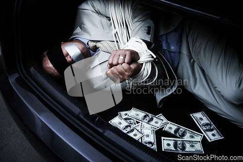 Image of Man, tied up and kidnap in car with money, ransom and crime for wealth, debt or financial negotiation. Person with blindfold, rope and cash in trunk for abduction, danger and risk or scared for life