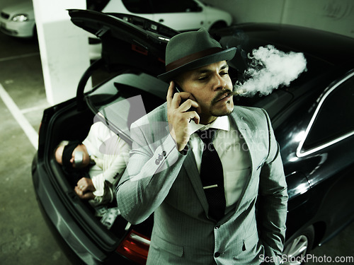 Image of Phone call, car and man with abduction in trunk for negotiation, kidnapping ransom and crime. Mafia, gangster criminal and person smoking in boot for terrorism, danger and robbery in parking lot