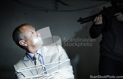 Image of Scared man, kidnap and hands with gun for crime, ransom and negotiation, interrogation or abduction risk at night. Criminal, senior person or corporate hostage with duct tape, and tied up in basement