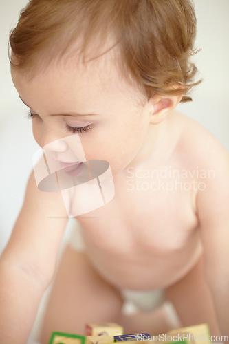 Image of Baby, building blocks and playing on bed, learning and education for child development in bedroom. Sensory, alphabet and english or letters, care and toys for growth, coordination and cognitive skill