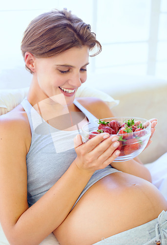 Image of Pregnant woman, strawberry and nutrition in bedroom with relax wellness for eating fruit in house. Young person, happy and prenatal health diet with natural food for vitamins and care in apartment