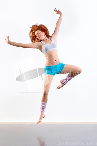 Image of Woman, dancer and jump pose in studio for creative expression exercise, white background or mockup space. Female person, aerobics and workout gymnastics or fit leap as energy, practice or training