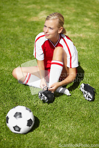 Image of Woman, soccer and tie shoelace on field, safety and start training for fitness, health or competition on pitch. Girl, shoes and football for preparation, ready and thinking for sport contest on grass