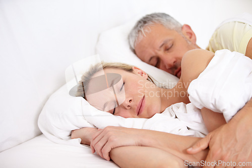 Image of Love, tired and mature couple sleeping in bed for cuddling together on weekend morning at home. Calm, peaceful and man and woman taking a nap and dreaming in bedroom for bonding at modern apartment.