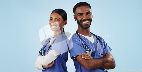 Image of Portrait, healthcare and arms crossed with a medicine team in studio on a blue background for trust. Medical, smile or wellness with a young man and woman nurse looking confident for treatment