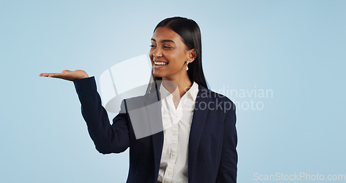 Image of Happy businesswoman, studio or palm for investment deal, financial offer or product mockup space. Hand, smile or proud Indian corporate worker on blue background marketing, advertising or finance