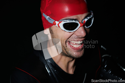 Image of A triathlete finds serene rejuvenation in a lake, basking in the tranquility of the water after an intense training session