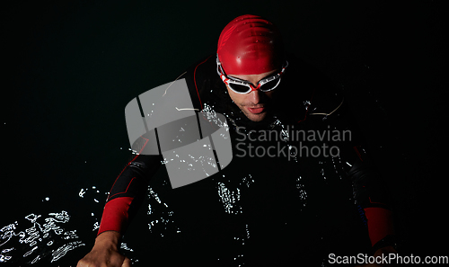 Image of A triathlete finds serene rejuvenation in a lake, basking in the tranquility of the water after an intense training session