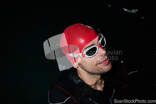 Image of A triathlete finds serene rejuvenation in a lake, basking in the tranquility of the water after an intense training session