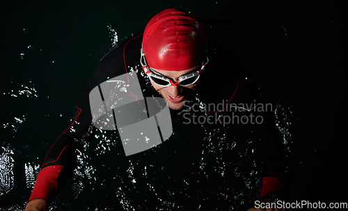 Image of A triathlete finds serene rejuvenation in a lake, basking in the tranquility of the water after an intense training session