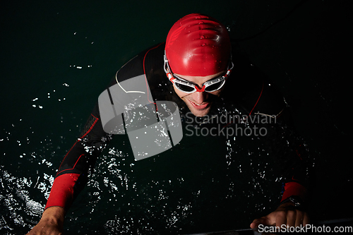 Image of A triathlete finds serene rejuvenation in a lake, basking in the tranquility of the water after an intense training session