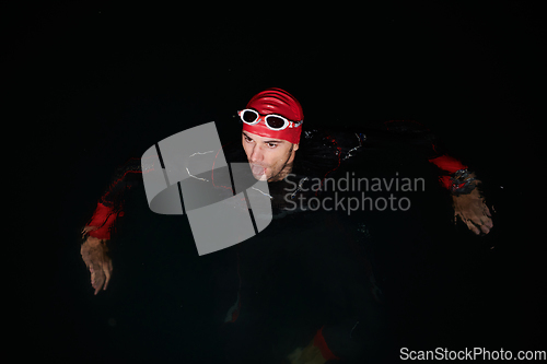 Image of A triathlete finds serene rejuvenation in a lake, basking in the tranquility of the water after an intense training session